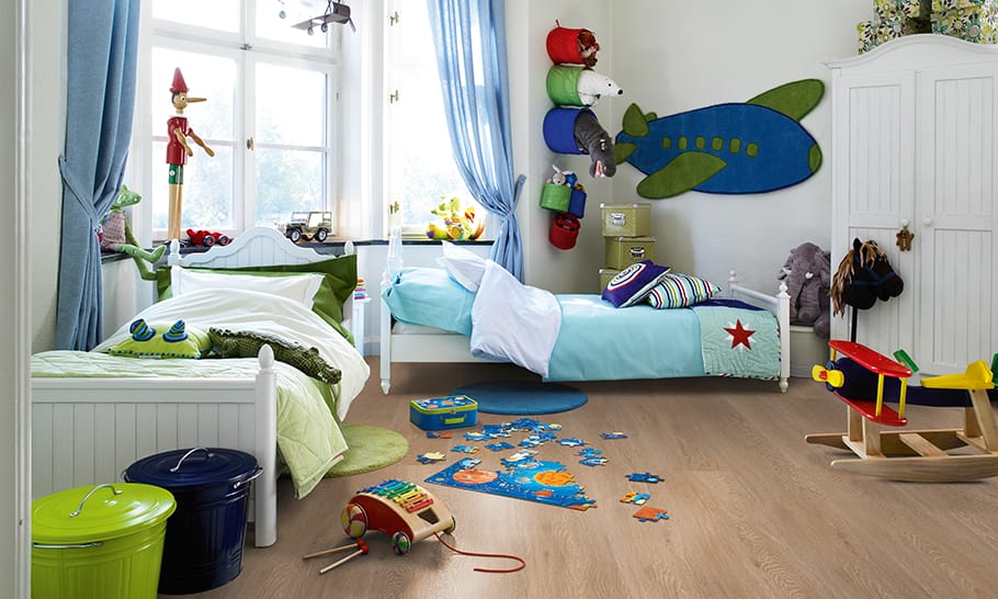 Habitación infantil con juguetes sobre el suelo laminado